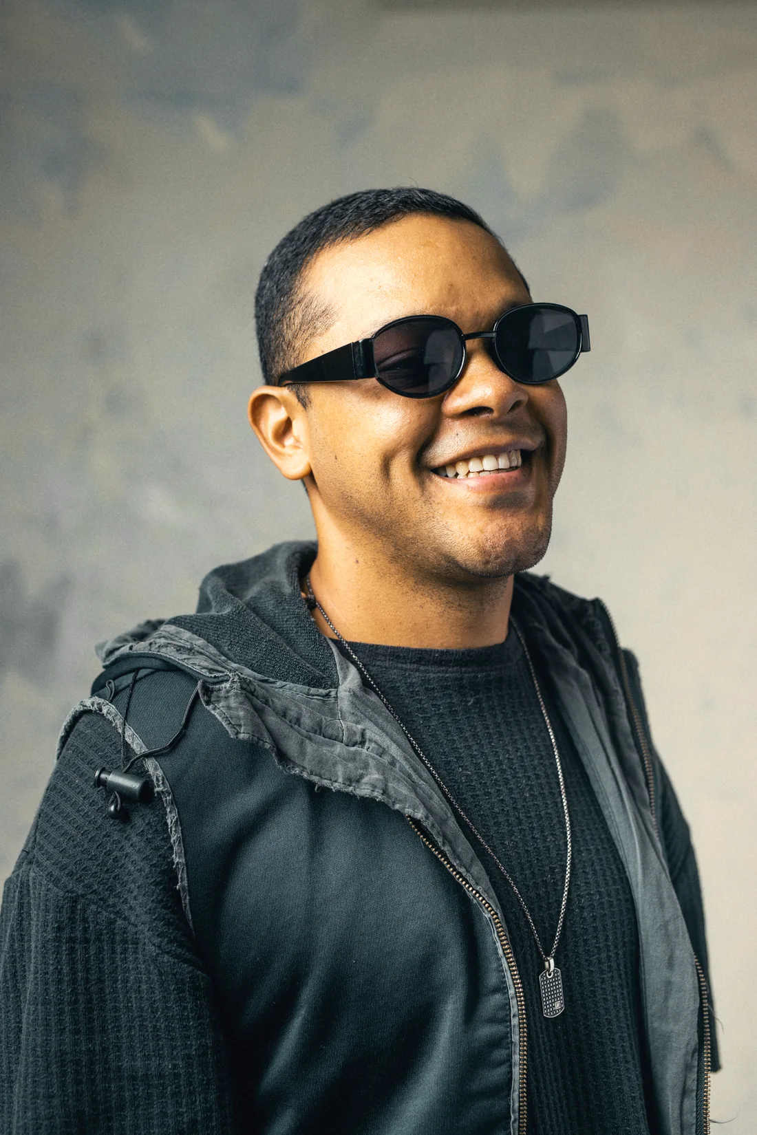 Editek sonriendo, con lentes oscuros y chaqueta negra